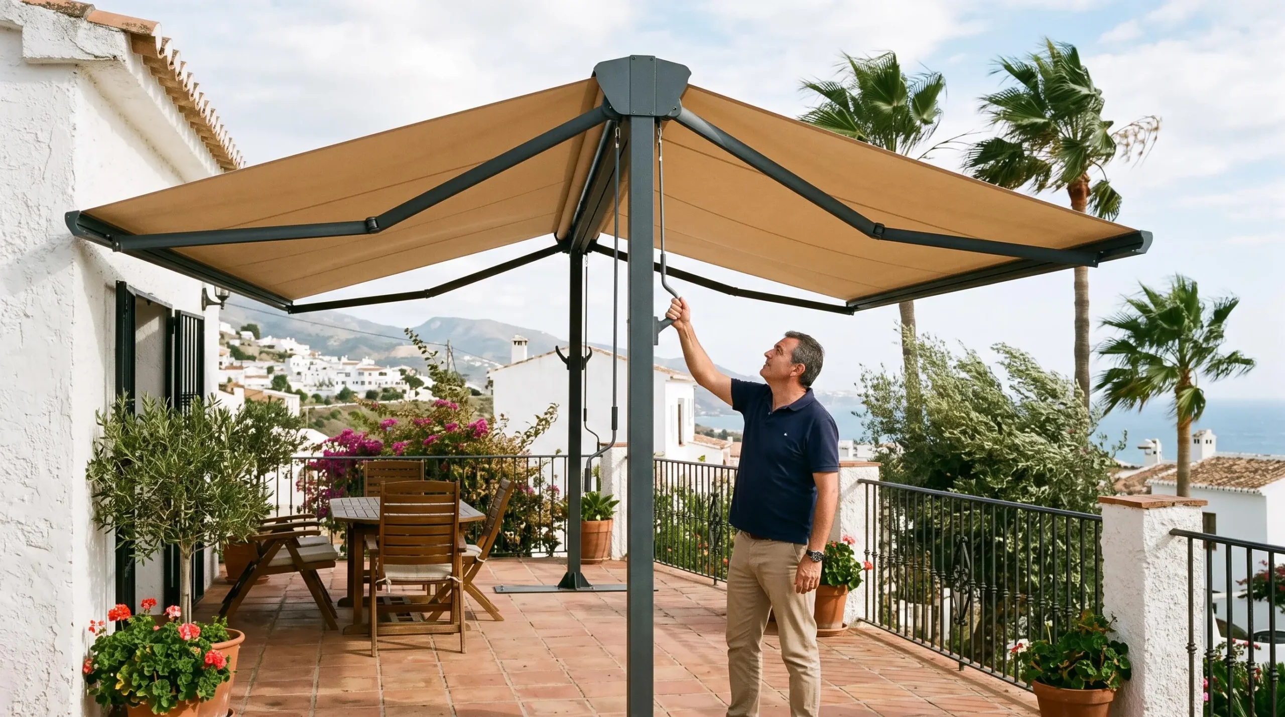 Un toldo a dos aguas extendido sobre una terraza ventosa de una casa española.